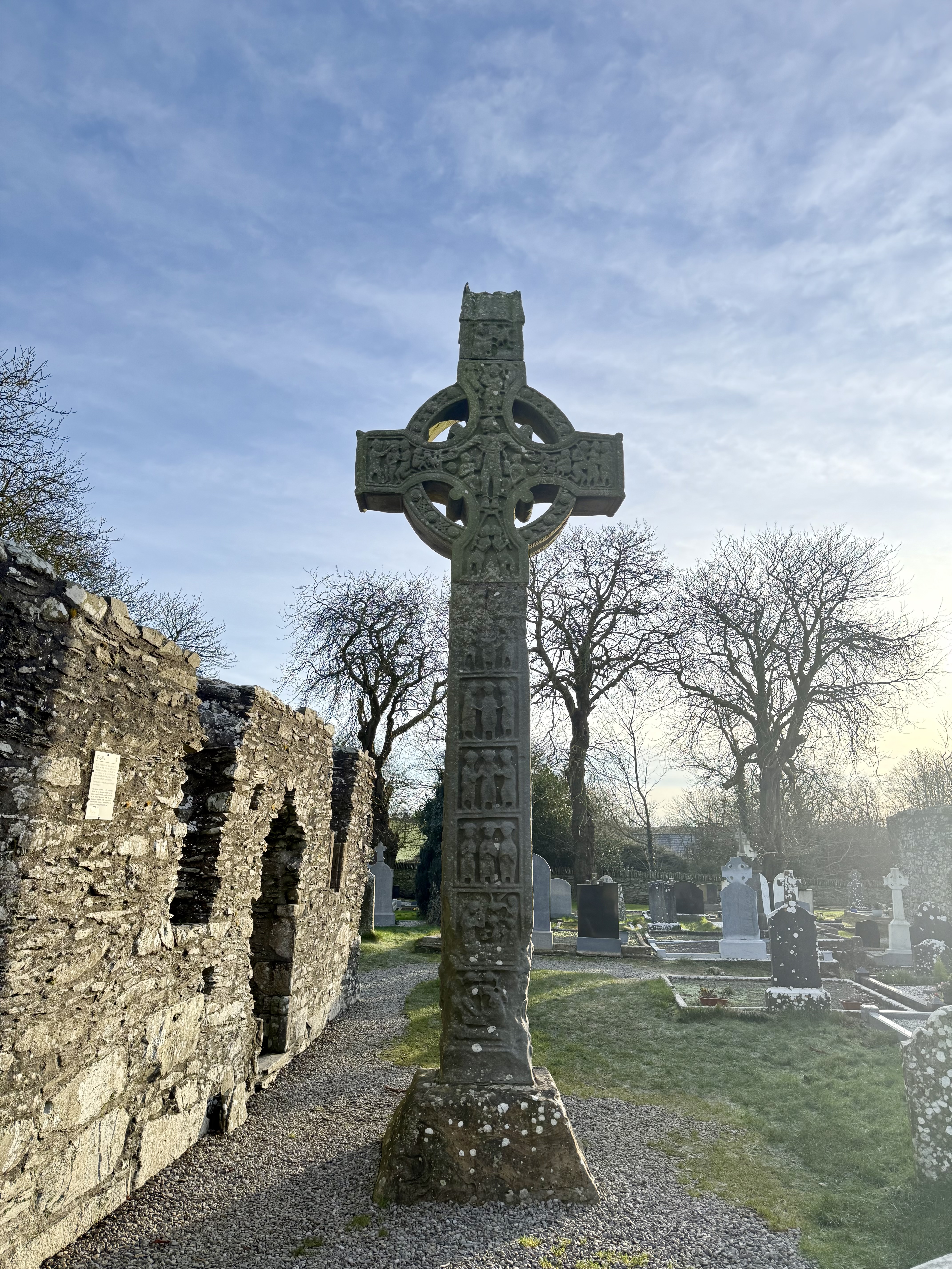 A millenia old Celtic cross, ten feet tall, in the middle of a graveyard
